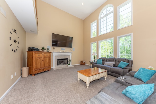 1090 Shetland Dr, South Lyon, MI 48178 - carpeted living area with a high ceiling, a tiled fireplace, and baseboards