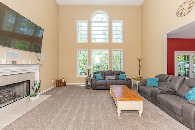 1090 Shetland Dr, South Lyon, MI 48178 - carpeted living room with a high ceiling, a tiled fireplace, healthy amount of natural light, and baseboards