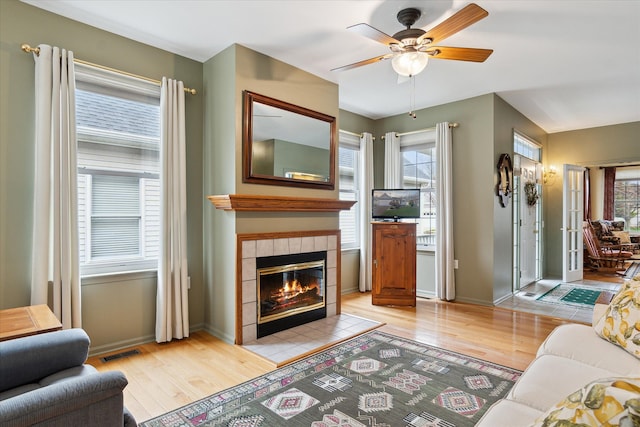 3818 Hillsdale Dr, Auburn Hills, MI 48326 - living room with light wood finished floors, a ceiling fan, a tile fireplace, and baseboards