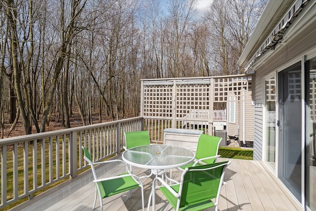 3818 Hillsdale Dr, Auburn Hills, MI 48326 - deck with outdoor dining space, central AC unit, and view of scattered trees