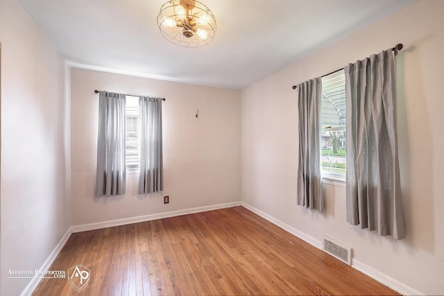 spare room featuring hardwood / wood-style flooring and baseboards