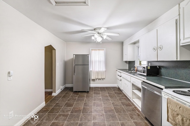 kitchen featuring appliances with stainless steel finishes, white cabinetry, baseboards, and a ceiling fan