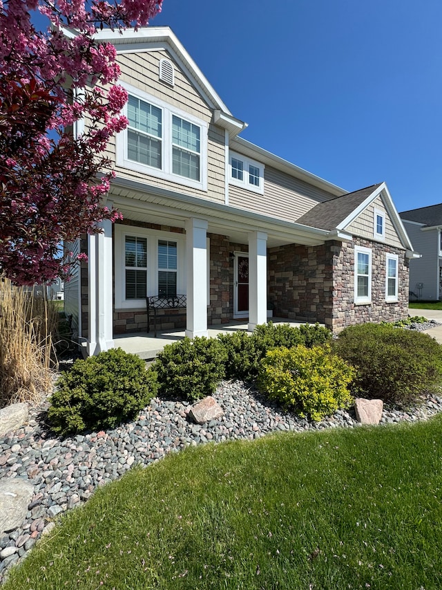 7051 Wildflower, Grand Blanc, MI 48439 - view of front of home featuring stone siding and a porch
