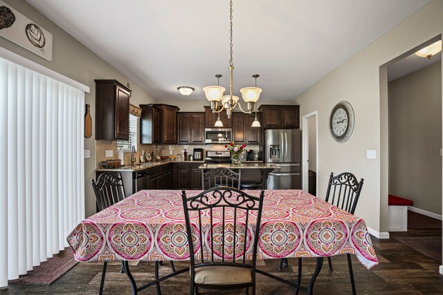 7051 Wildflower, Grand Blanc, MI 48439 - dining room with dark wood finished floors, baseboards, and a chandelier