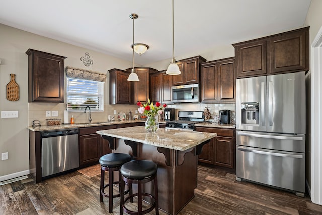 7051 Wildflower, Grand Blanc, MI 48439 - kitchen featuring appliances with stainless steel finishes, a sink, dark brown cabinets, and dark wood-type flooring