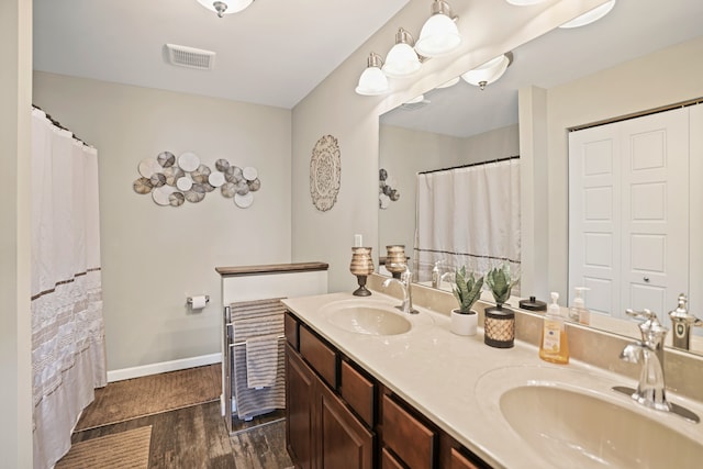 7051 Wildflower, Grand Blanc, MI 48439 - full bathroom featuring wood finished floors, double vanity, and baseboards
