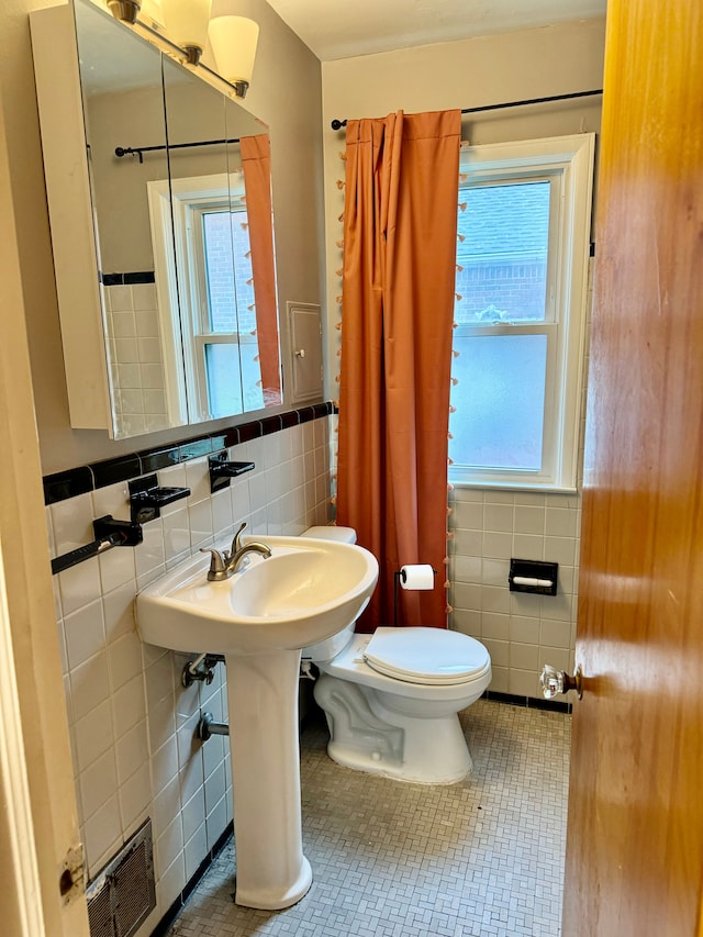 11427 Mercedes, Redford, MI 48239 - bathroom featuring tile walls, toilet, tile patterned floors, and a wainscoted wall