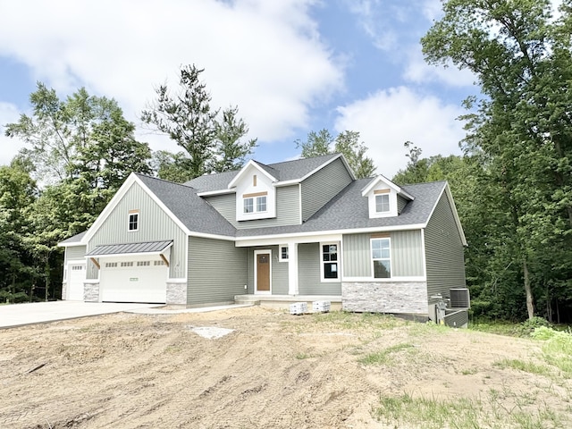1969 Northfield Ct SW, Byron Center, MI 49315 - view of front of house with stone siding, concrete driveway, a shingled roof, board and batten siding, and covered porch