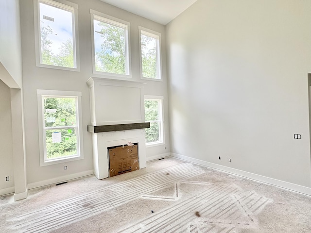 1969 Northfield Ct SW, Byron Center, MI 49315 - unfurnished living room featuring a towering ceiling, healthy amount of natural light, and a fireplace