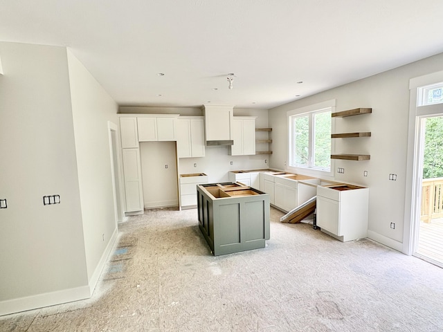 1969 Northfield Ct SW, Byron Center, MI 49315 - kitchen with a kitchen island, open shelves, white cabinets, and light colored carpet