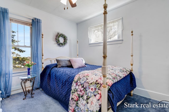 carpeted bedroom with crown molding, baseboard heating, and a ceiling fan