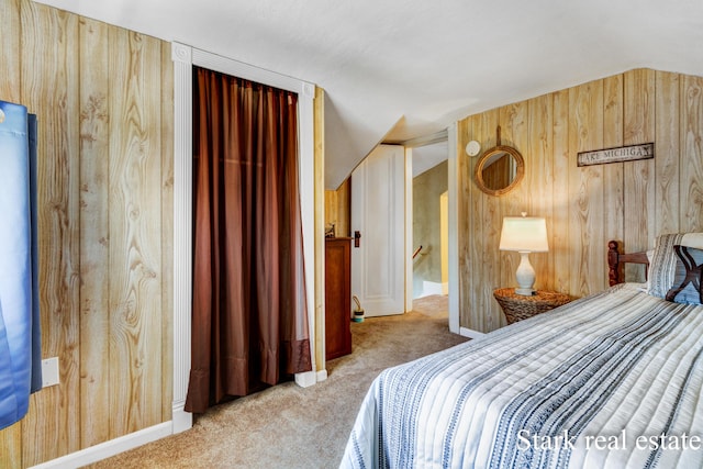 carpeted bedroom featuring wood walls and vaulted ceiling