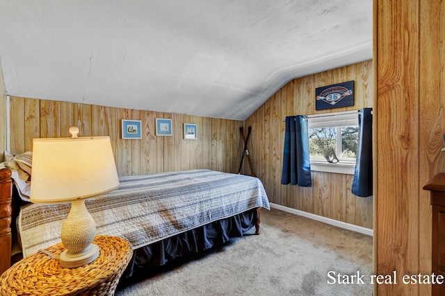carpeted bedroom with lofted ceiling and wooden walls