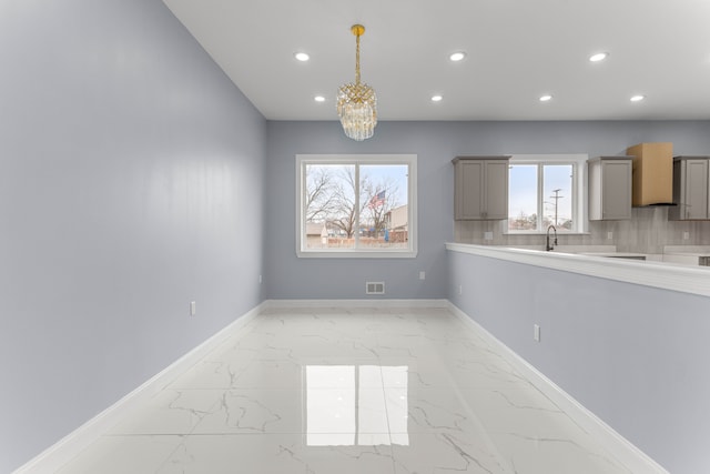 31460 James St, Garden City, MI 48135 - unfurnished dining area featuring light marble finish floors, recessed lighting, a chandelier, baseboards, and healthy amount of natural light