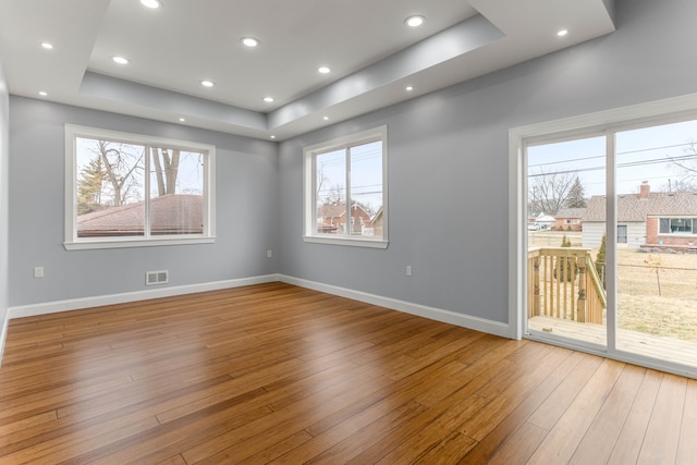 31460 James St, Garden City, MI 48135 - unfurnished room featuring a tray ceiling, healthy amount of natural light, wood-type flooring, baseboards, and recessed lighting