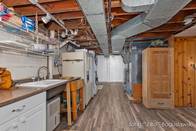1017 Pearl St, Belding, MI 48809 - unfinished below grade area with a sink, white fridge with ice dispenser, and wood finished floors