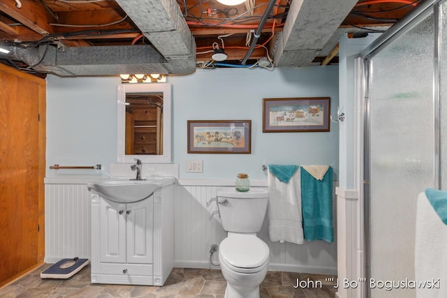 1017 Pearl St, Belding, MI 48809 - bathroom featuring a wainscoted wall, vanity, toilet, and a shower with shower door