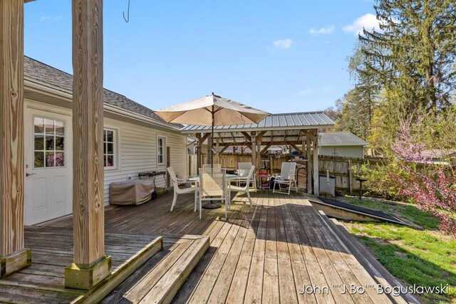 1017 Pearl St, Belding, MI 48809 - deck featuring outdoor dining space, a fenced backyard, and a gazebo