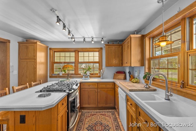 1017 Pearl St, Belding, MI 48809 - kitchen featuring gas range, light countertops, brown cabinets, a sink, and white dishwasher