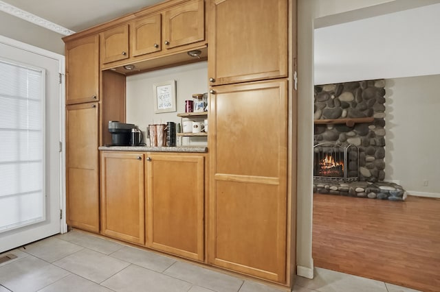 1699 Brentwood Dr, Wixom, MI 48393 - kitchen featuring light tile patterned floors and a stone fireplace
