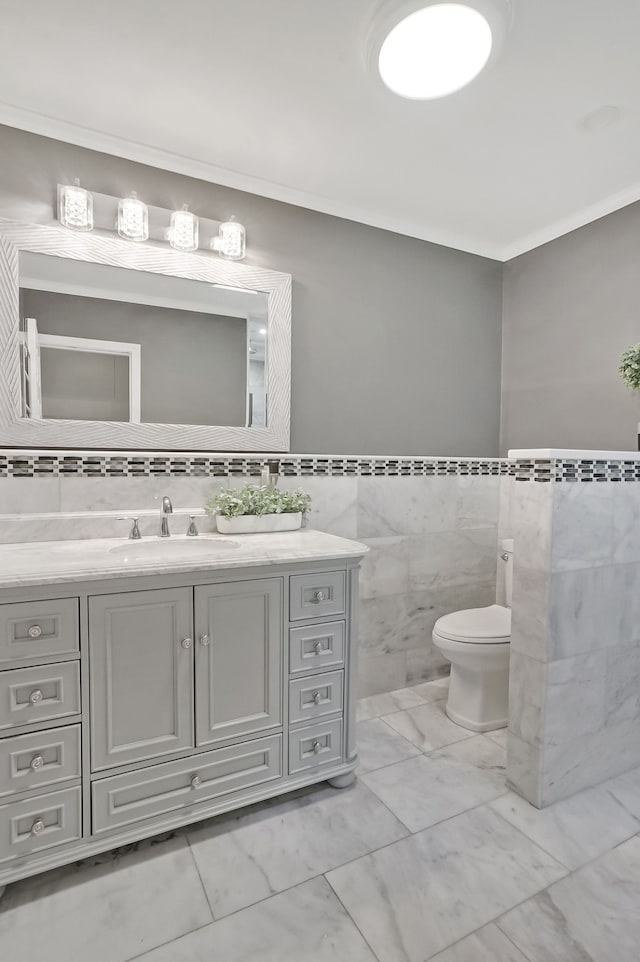 1699 Brentwood Dr, Wixom, MI 48393 - bathroom with tile walls, ornamental molding, vanity, toilet, and marble look tiles