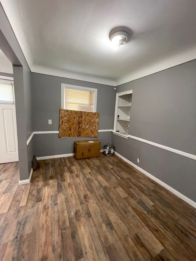 16450 Pembroke Ave, Detroit, MI 48235 - unfurnished room featuring wood finished floors, baseboards, built in shelves, and plenty of natural light