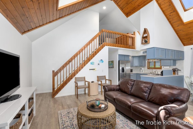 7964 W Royal Rd, Stanwood, MI 49346 - living room with high vaulted ceiling, a skylight, stairway, light wood finished floors, and wooden ceiling