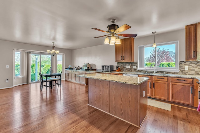 kitchen featuring a sink, tasteful backsplash, a kitchen island, and healthy amount of natural light