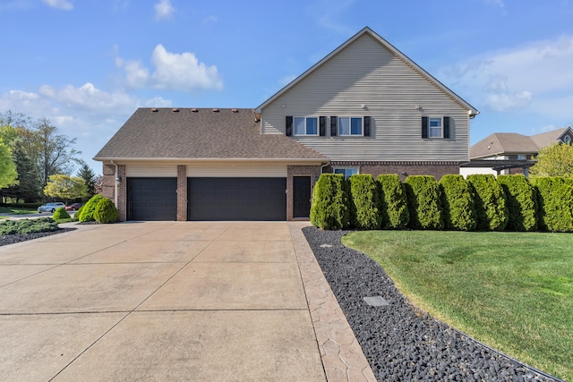 view of front of house featuring an attached garage, brick siding, driveway, and a front lawn