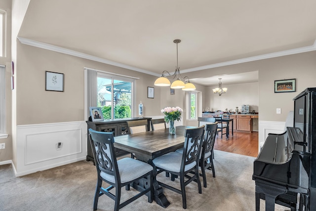 dining room featuring crown molding, a wainscoted wall, and a chandelier