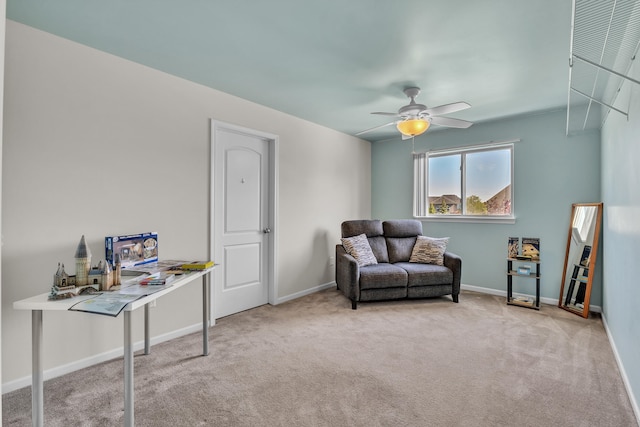 sitting room featuring carpet, baseboards, and a ceiling fan