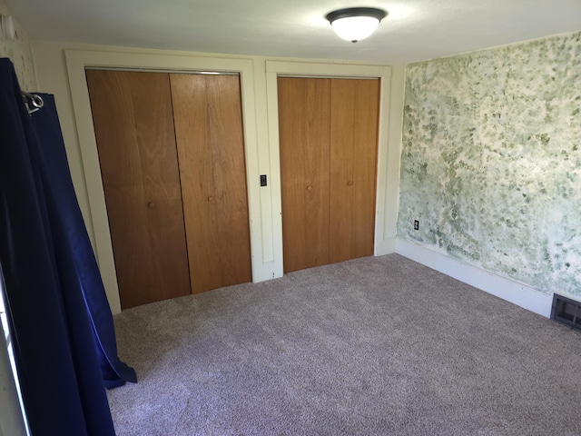 120 S Mackinaw St, Waldron, MI 49288 - unfurnished bedroom featuring two closets, carpet flooring, and wallpapered walls