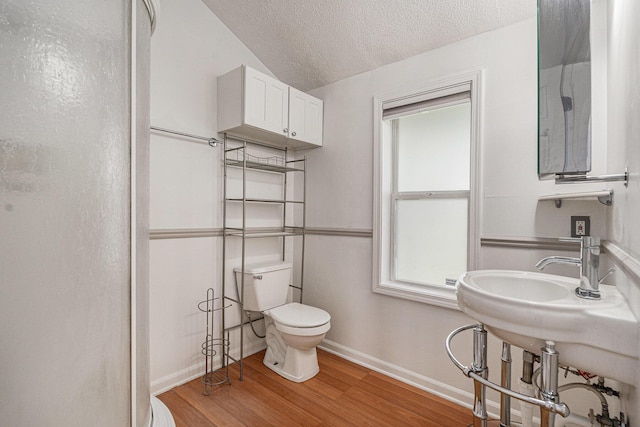 bathroom featuring wood finished floors, a textured ceiling, toilet, and baseboards