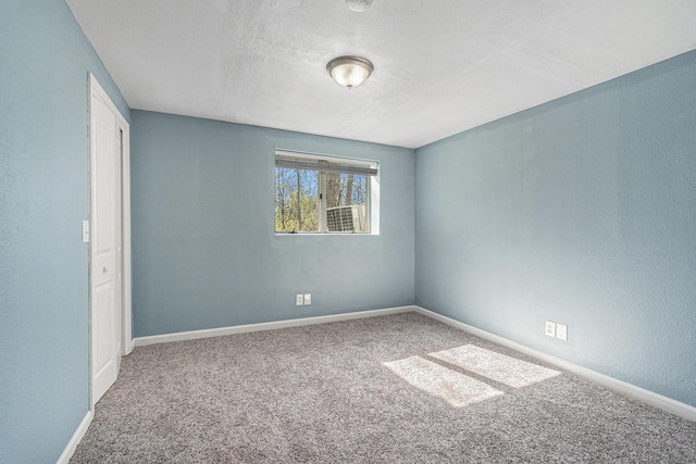 unfurnished bedroom with carpet, baseboards, and a textured ceiling