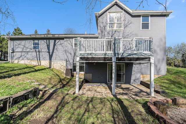 back of house featuring a yard, a deck, and a patio area