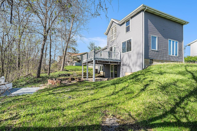 view of side of home with a deck and a lawn