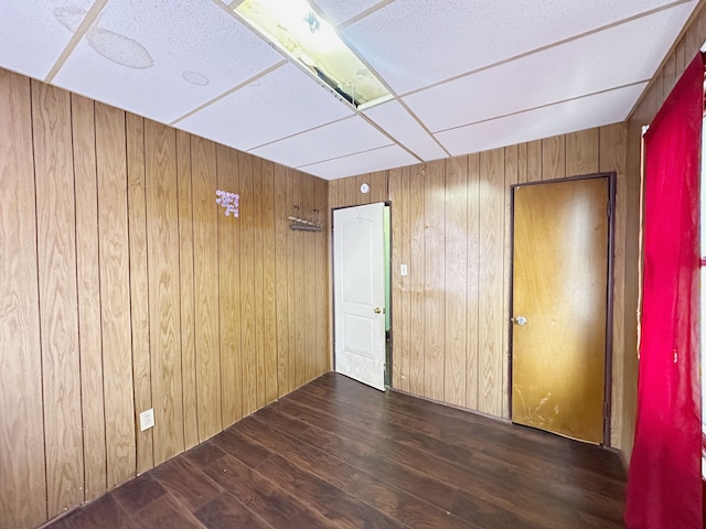 unfurnished room featuring wooden walls and wood finished floors