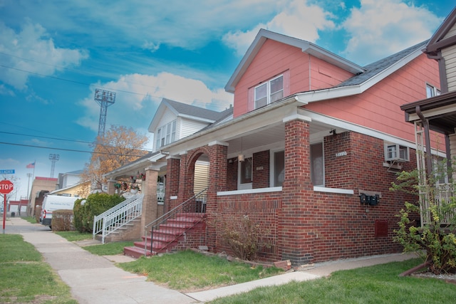 view of front facade featuring brick siding and covered porch