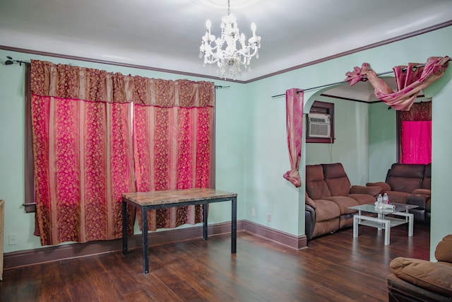 living area with wood finished floors, a chandelier, baseboards, crown molding, and arched walkways