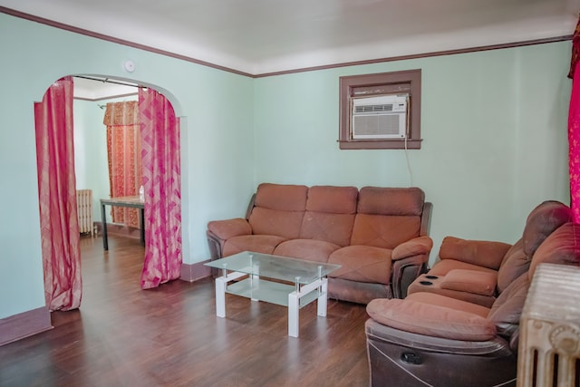living area featuring radiator, dark wood-type flooring, cooling unit, crown molding, and arched walkways