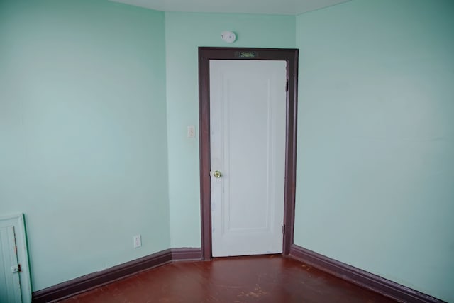 unfurnished room with baseboards and concrete floors