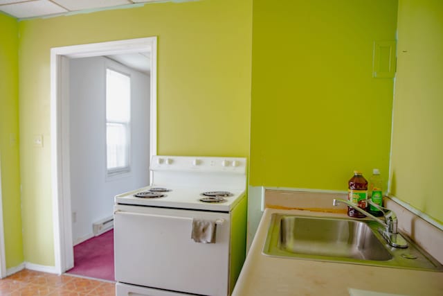 kitchen with white range with electric cooktop, a sink, a baseboard heating unit, and baseboards