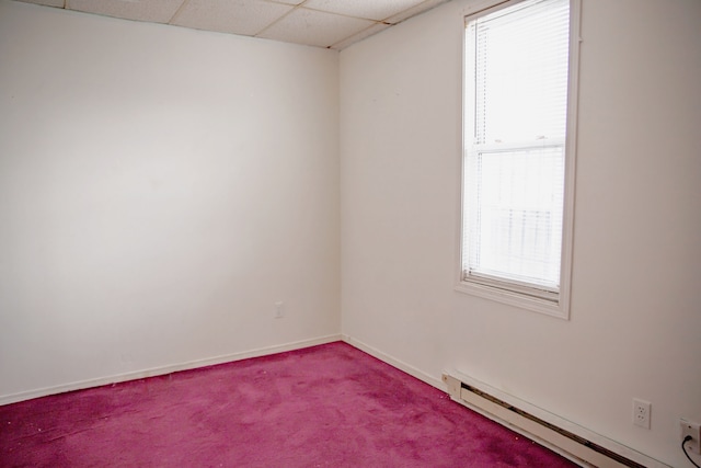 unfurnished room with a baseboard heating unit, healthy amount of natural light, carpet floors, baseboards, and a paneled ceiling