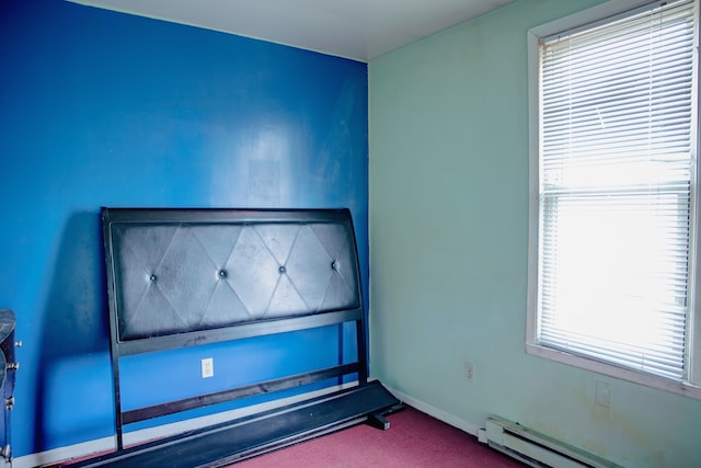 unfurnished room with dark colored carpet, a baseboard heating unit, and baseboards