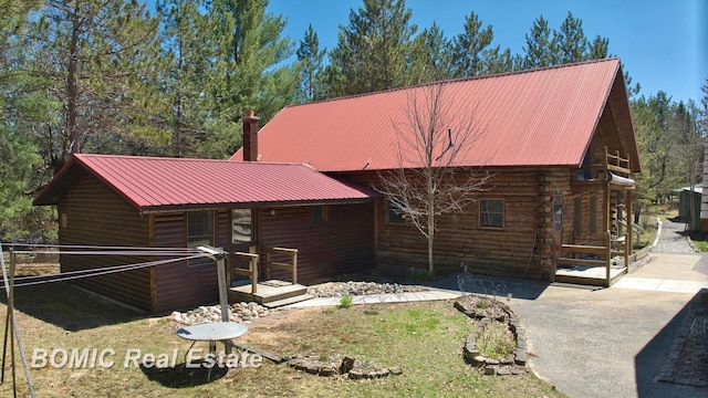 940 Wood River Rd, Grayling, MI 49738 - view of property exterior with metal roof and a patio