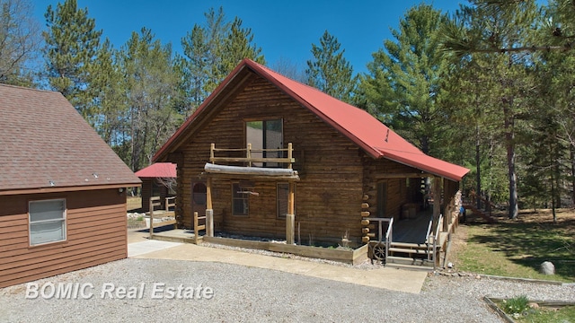940 Wood River Rd, Grayling, MI 49738 - view of front of house with log siding and metal roof