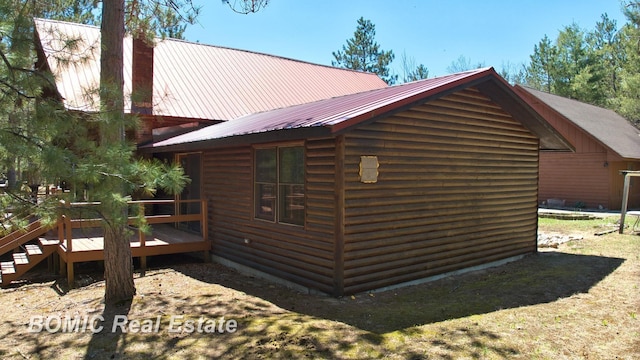 940 Wood River Rd, Grayling, MI 49738 - view of property exterior featuring a wooden deck, a chimney, metal roof, and an outdoor structure