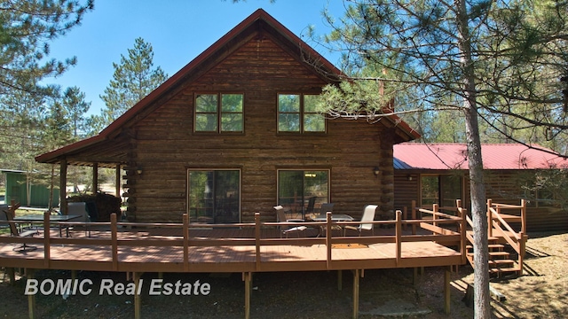 940 Wood River Rd, Grayling, MI 49738 - rear view of property featuring log siding, a wooden deck, and metal roof