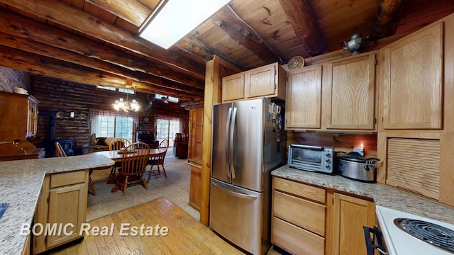 940 Wood River Rd, Grayling, MI 49738 - kitchen featuring freestanding refrigerator, light countertops, log walls, beamed ceiling, and a chandelier