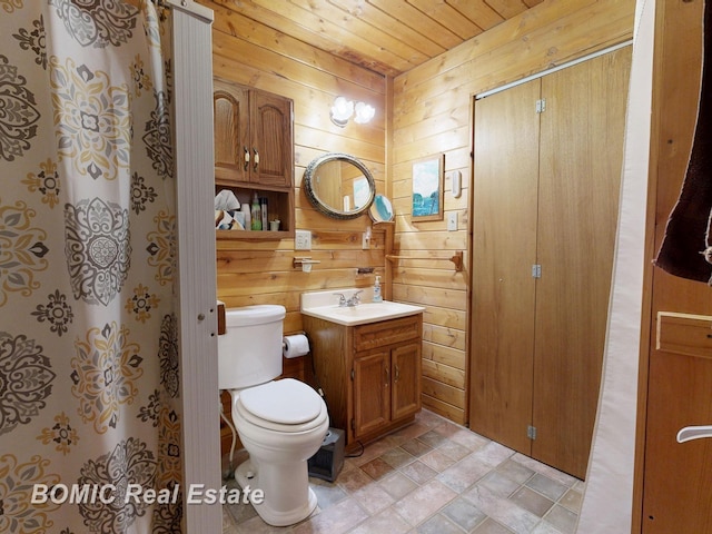 940 Wood River Rd, Grayling, MI 49738 - full bath featuring wooden walls, toilet, stone finish flooring, wooden ceiling, and vanity